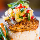 Seasoned with The Spice Lab Best Seller Seasoning Set, the grilled fish is finished with pineapple salsa and served atop a mound of white rice, garnished with greens, alongside sautéed green beans and carrots.
