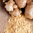 Fresh ginger root and a small pile of The Spice Lab Organic Ground Ginger, a popular baking spice from The Spice Lab, are displayed on a wooden surface.