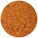 Close-up of a circular mound of The Spice Lab Smoked Ghost Pepper Sea Salt, a brown, coarse-grained seasoning with visible red and yellow flecks, displayed against a white background.