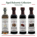 Four bottles from the Georgetown Olive Oil Co. Aged Balsamic Collection are arranged in a row, featuring distinct label designs and showcasing both dark and light balsamic vinegars aged 12, 18, 18, and 25 years from Georgetown Olive Oil Co.