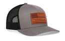 The Haka Hat American Flag Trucker Hat features a gray-black design with a mesh back and a leather flag patch on the front panel.