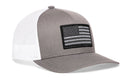 The Haka Hat American Flag Trucker Hat features a gray front and bill, white mesh back, and a black and gray flag patch—classic USA tactical snapback style by Haka Hat.