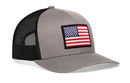 The Haka Hat American Flag Trucker Hat is a gray and black snapback with a mesh back and an American Flag patch on the front.