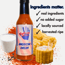 A bottle of Culture Hot Sauce American Dream, featuring corn, ranch dip, pepper, cayenne chili pepper, and spices—highlighted with ingredient qualities such as real ingredients, no added sugar, locally sourced components, and harvested ripe. Ranch seasoning lends a creamy twist to the bold flavor profile.