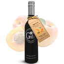 A bottle of Georgetown Olive Oil Co. APRICOT White Balsamic Vinegar | Barrel Aged Modena ITALY, adorned with a tan tag, displayed in front of a background featuring a halved apricot and a whole apricot with leaf. This premium white balsamic vinegar from Georgetown Olive Oil Co., barrel aged in Modena, Italy, delivers a delicate apricot sweetness that enhances any culinary creation.