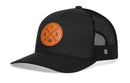 The Haka Hat Austin Trucker Hat Leather | Black ATX X Snapback features a black leather patch with a circular brown Texas and "TAX" cross design, plus a small H logo on the mesh back—perfect for any Austin adventure.