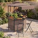 DirectDeals Grill Gazebo with Shelves, Hooks & Double Roof Canopy features chairs and a countertop for fruit, snacks, and drinks—surrounded by plants, flowers, and a wooden fence on a stone-tiled patio.