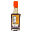 A clear glass bottle of Taycte Aged Balsamic Steak Sauce with an orange cap, showing the back label with nutrition facts and product information. This exceptional sauce is crafted with 25-30 year Balsamic Vinegar of Modena, delivering a rich and authentic Italian flavor to enhance your grilling experience.