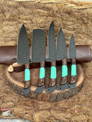 Five Texan Knives from the Premium Knofe Set feature 13" forged stainless steel blades and wenge wood & resin handles, arranged on a wooden board with a brown leather sheath in the background.
