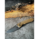 The Spaceman Knives N1 EDC by Spaceman Knives, featuring a textured tan Micarta handle and a silver Sandvik steel blade, rests on gray stone with a rough wooden log in the background.
