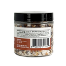 Clear jar of B.T. Leigh’s Chipotle & Lime Finishing Salt filled with coarse salt, dried chili flakes, and lime peel, showing the nutrition facts label and barcode on the back.