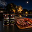 Two bottles of BuffalowBBQ Signature Blend BBQ Rub sit next to a wooden cutting board with sliced steak and grilled vegetables on a counter at night beside a swimming pool.