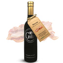 A dark glass bottle of Georgetown Olive Oil Co BACON Infused High Polyphenols Extra Virgin Olive Oil with a gold cap, a brown tag featuring bacon images, and a faint bacon background. The label reads “Georgetown Olive Oil Co., Washington, DC 20007.”.