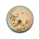A glass jar of SALTOPIA Infused Sea Salts' HOWDY DO Bacon & Ranch Seasoning, featuring a light blend with dried green herbs, is shown from above on a white background.