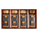 The Spice Wheel Sweet Baking 4 Pack Starter Kit features four glass jars—each filled with allspice powder, cinnamon powder, clove powder, and ground nutmeg—neatly arranged in a rectangular box with orange and white accents. Each jar bears a black spice label and is topped with a wooden lid, reflecting the signature style of Spice Wheel.