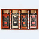 The Spice Wheel Foundations of Flavor Gift Set by Spice Wheel showcases four essential spices—Hungarian paprika, white pepper, smoked paprika, and Himalayan pink sea salt—elegantly presented in individually labeled jars with wooden lids, all arranged against a crisp white background.
