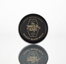 A round tin of Conditioning Natural Beard Balm by The Immaculate Beard is shown on a white background. The black lid features the product name and highlights that it is handcrafted with citrus peel, vanilla musk, and tonka bean—making it an ideal choice for natural beard care and effortless styling.