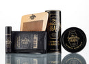 A collection of men’s grooming products from The Immaculate Beard, featuring the Conditioning Natural Beard Oil, is arranged on a reflective surface alongside beard balm, beard wash, a comb, and peppermint lip balm.
