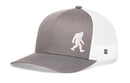 The Haka Hat Bigfoot Trucker Hat is a gray and white snapback featuring a white Sasquatch silhouette on the front panel and a mesh back.