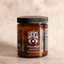A box of 2 handcrafted Spice Witch Chili Crisp jars, each 6 oz (177 mL), made with avocado oil. The jars feature black lids, white text, and an eye logo on the label. Brand: Spice Witch.
