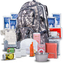 A gray camouflage Blue Seventy Two Ultimate Tactical 3 Day Emergency Kit For Preppers backpack surrounded by emergency supplies, including drinking water, a first aid kit, stove, food rations, hygiene items, whistle, cards, flashlight, and metal cup.