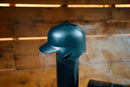 A black Baseball Batting Helmet BBQ Chimney Cap - Black | Pimp My Grill® sitting atop a pellet grill with smoke rising from beneath it.