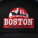 The Haka Hat Boston City On A Hill Trucker Hat features a black base, red and white embroidered Boston skyline patch with “City on a Hill” and “Boston Massachusetts,” plus a classic snapback design for comfort and style.