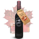 A dark glass bottle of Georgetown Olive Oil Co BOURBON MAPLE Balsamic Vinegar, barrel aged in Modena, Italy, stands with a tag in front of a maple leaf and two whiskey glasses filled with ice. The label displays the Georgetown Olive Oil Co. brand and Washington, DC.