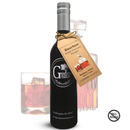 A dark glass bottle labeled "Georgetown Olive Oil Co Bourbon White Balsamic" by Georgetown Olive Oil Co. sits next to a glass of brown liquid and a decanter. Crafted with aged white balsamic vinegar from Modena, Italy, this refined display features a "No Alcohol" symbol in the lower right corner.