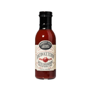 A glass bottle of Brownwood Farms Bacon Ketchup, featuring a cream-colored label with red and black text and topped with a black cap, is displayed against a plain white background.
