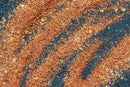 A close-up reveals the World Spice Americana Tasting Flight from World Spice—an aromatic blend scattered in streaked patterns across a dark gray surface, offering an enticing introduction to regional flavors inspired by the USA.