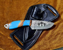 The Texan Knives Custom Handmade Bull Sheath Leather Knife features a 4.5" Damascus steel blade and a blue-brown handle, displayed on its leather sheath atop brown fabric.
