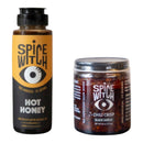 The Spice Witch Hot Honey & Chili Crisp Bundle from Asheville features a squeeze bottle of hot honey and a jar of +Chili Crisp Black Garlic, both with bold black-and-yellow labels and an eye graphic.