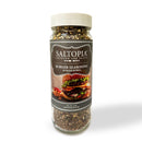 A clear jar of SALTOPIA Infused Sea Salts with a white lid and burger image, featuring Saltopia Smoky Blended Salt: BURGER BUDDY—a versatile seasoning perfect for burgers and more.