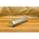 The Butcher BBQ Premium Pellet Smoke Tube 12" by Butcher BBQ is a metallic grill smoker accessory on a wooden surface with a brown paper background, perfect for infusing dishes with rich wood smoke flavor.