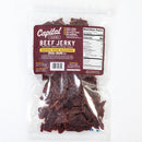 A clear bag of Chiles and Smoke Chiles & Smoke Sedona Sand Beef Jerky – Southwest Garlic & Chile features a brown label displaying nutrition facts and ingredients. The jerky's quality is showcased through the see-through packaging, emphasizing its small-batch craftsmanship. The label highlights that it is MSG, gluten, and dairy free.