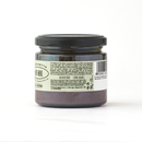 A glass jar with a black lid contains a dark spread labeled Taycte Famiglia Crispino Black Olive Bruschetta Spread — Italian Olive Tapenade. This gluten-free, vegan Calabrian tapenade from Taycte is perfect as an authentic Italian bruschetta topping. The label displays ingredients, barcode, and dietary notes. The jar is photographed against a white background.
