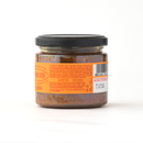 A glass jar with a black lid containing a chunky, reddish-brown food product—Taycte Crispino Bruschetta Pomodori Secchi, a Calabrian sun-dried tomato spread that is vegan and gluten-free. The jar features an orange label with text, a barcode, and the brand name Taycte.