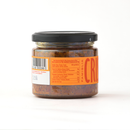 A glass jar with a black lid holds Taycte Crispino Bruschetta Pomodori Secchi — Calabrian Sun-Dried Tomato Spread, a chunky, reddish condiment perfect for adding bold flavor to your dishes. The jar features a barcode, nutrition facts, and an orange label partially displaying the word FAMIGLIA. This vegan, gluten-free spread from Taycte is an ideal addition to appetizers and snacks.