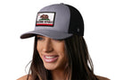 A woman sports the Haka Hat California Flag Trucker Hat in gray-black, featuring a CA Republic patch, for a laid-back look.