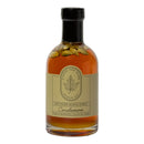 A glass bottle of Under The Bark Syrup Co Cardamom Maple Syrup with whole cardamom pods inside. The beige label reads “Under The Bark Syrup Co 100% Pure Maple Syrup Cardamom. Made in Minnesota, 8.4 fl oz (250 ml).”.
