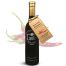 A bottle of Georgetown Olive Oil Co. Red Chili Cayenne Infused High Polyphenols Extra Virgin Olive Oil with a brown tag sits in front of blurred red chili peppers on a white background. This spicy oil from Georgetown Olive Oil Co. features an infusion of red chili cayenne, delivering vibrant, bold heat that's perfect for enhancing your favorite dishes.