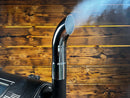 A chrome Pimp My Grill Chrome Pellet Grill Smoke Stack Trucker Series Fits GMG / Yoder Smokers attached to a grill, emitting a wisp of smoke.