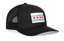 The Haka Hat Chicago Flag Trucker Hat | Black City Snapback features a black mesh build and a front panel embroidered Chicago flag patch with four red stars and light blue stripes in the signature Haka 5.0 trucker style.