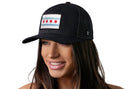 A smiling woman with long brown hair wears the Haka Hat Chicago Flag Trucker Hat | Black City Snapback, featuring a city flag patch with four red stars and two blue stripes by Haka Hat. The background is white.