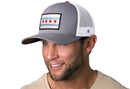 A man smiles to the side, wearing the Haka Hat Chicago Flag Trucker Hat—a stylish gray-white city snapback that proudly displays Chicago's iconic emblem.
