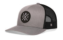The Haka Hat Chicago Trucker Hat | Gray-Black CHI X Snapback features a gray and black mesh design, curved brim, structured front, and a round embroidered “CHI” patch with a white graphic on the front.