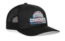 The Haka Hat Chicago Windy City Trucker Hat is a black mesh cityscape snapback with a curved brim and front patch reading "Windy City Chicago Illinois," accented by red stars and a stylized skyline.