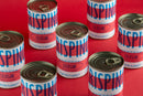 Several cans labeled Taycte Famiglia Crispino Italian Cherry Tomatoes — Calabrian Ciliegini are arranged on a bright red background. The cans feature vibrant blue and red typography, emphasizing these authentic Italian cherry tomatoes from Taycte—a prime example of premium Calabrian Ciliegini among distinguished tomato products.