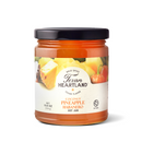 A glass jar of Texan Heartland Coconut Pineapple Habanero Hot Jam with a label featuring pineapple chunks and a habanero pepper.
